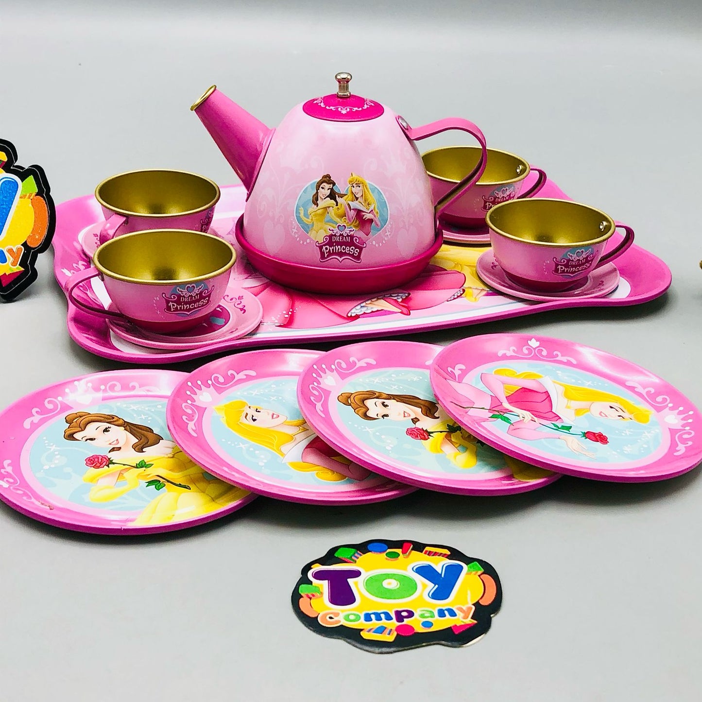 Children's toy tea set with princess design on a gray background