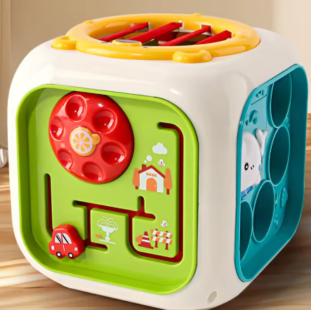 Colorful children's puzzle cube with various compartments on a wooden surface