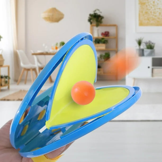 Toy with a green base and blue rim held in a hand, blurred indoor background