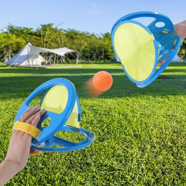 Two blue and yellow disc thrower devices on grass with a ball in the air.