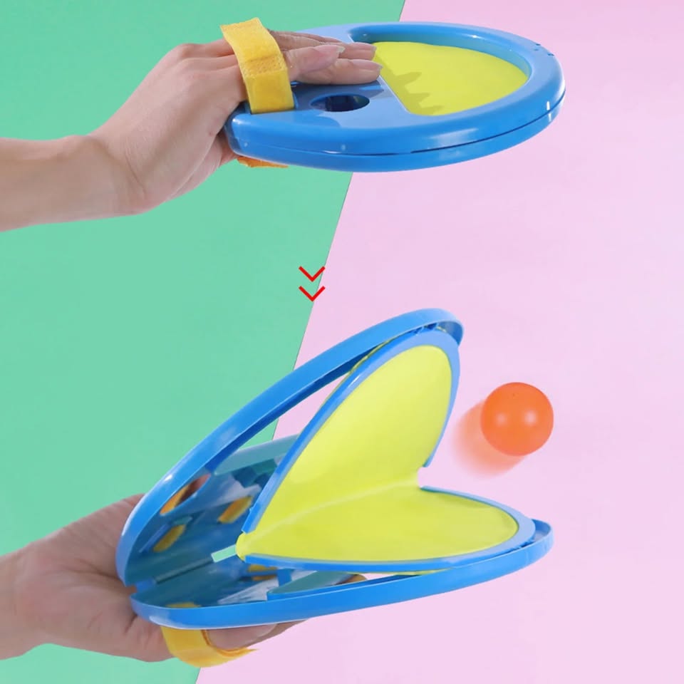 Hand holding a blue and yellow toy device with a ball on a colorful background
