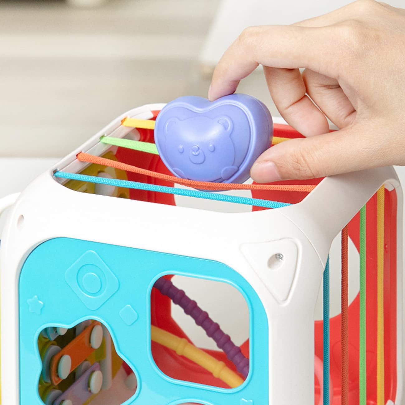 Colorful toy with a heart-shaped object being held by a hand