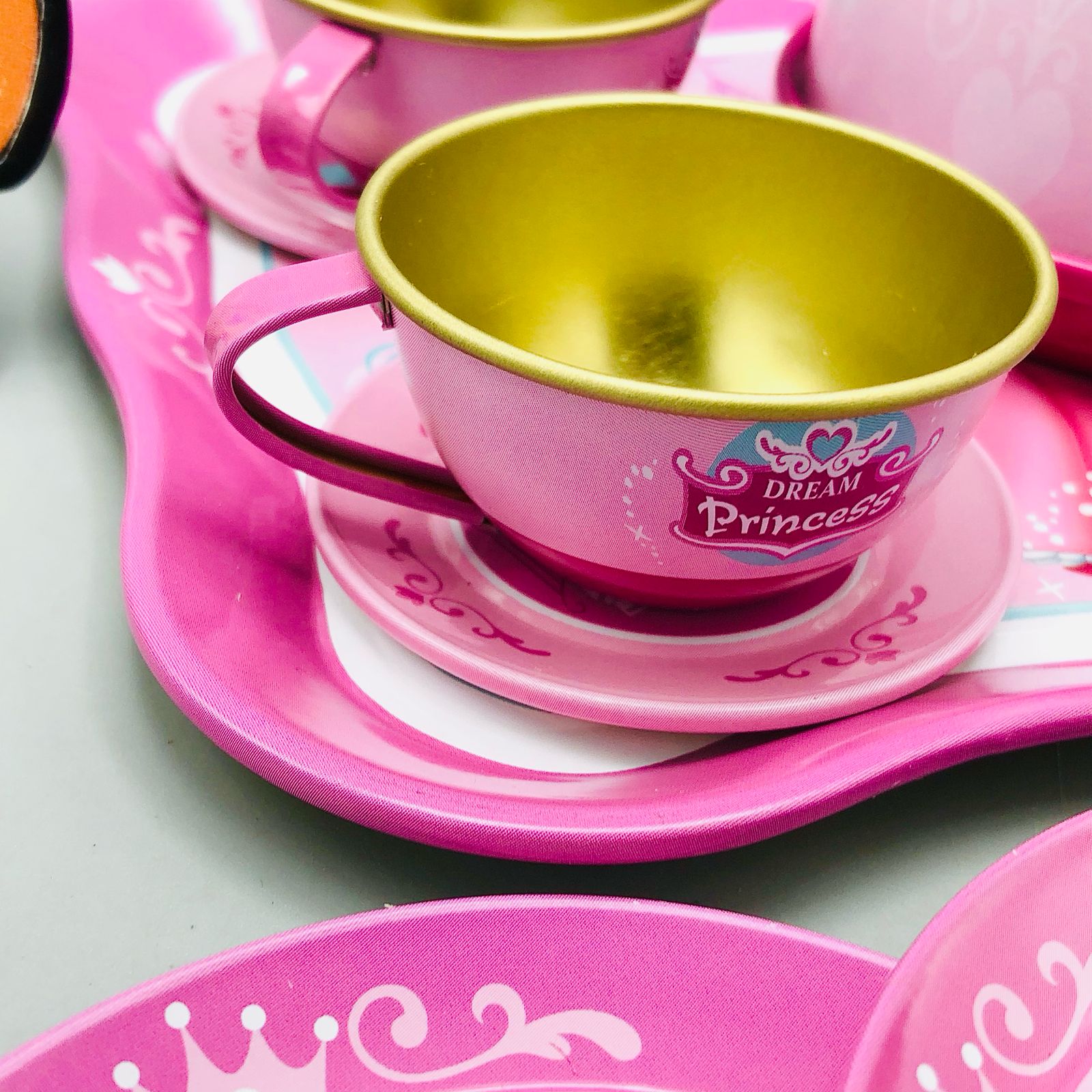 Pink and gold princess-themed tea set on a light gray background