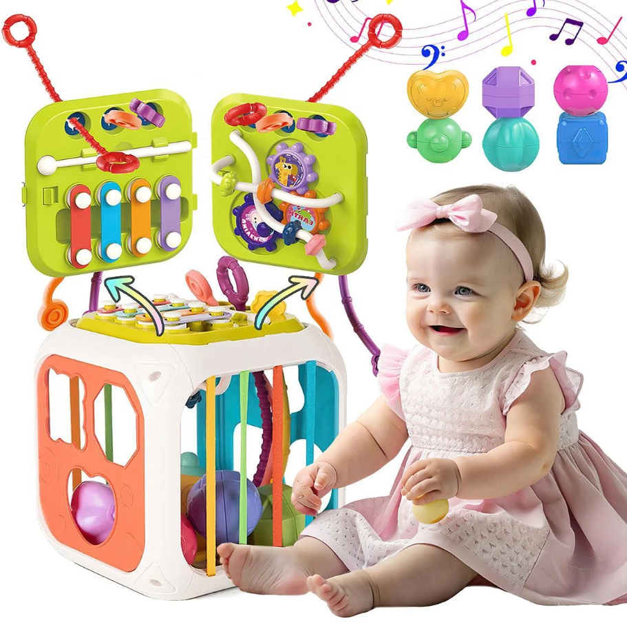 Baby playing with a colorful activity cube and toys on a white background