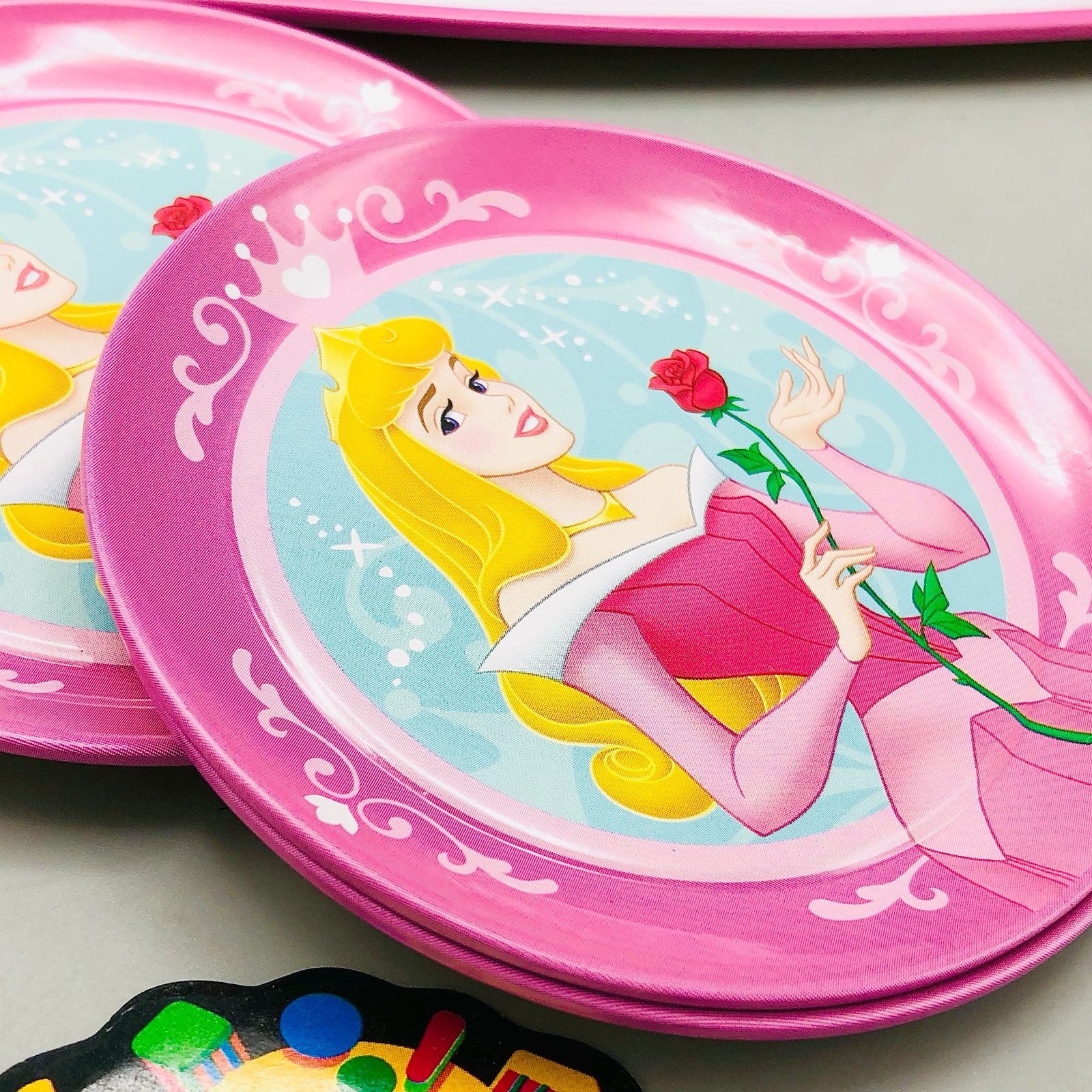 Pink plate with Disney princess design on a light gray surface